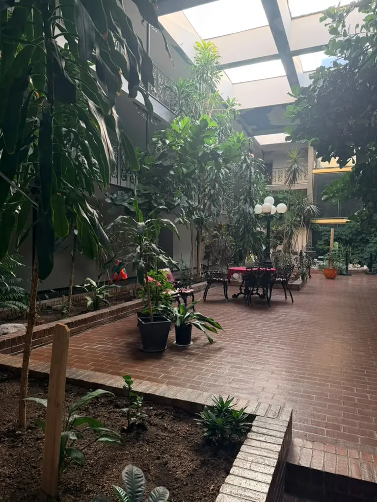 Lush indoor garden atrium at Garden Cove Hotel Suites